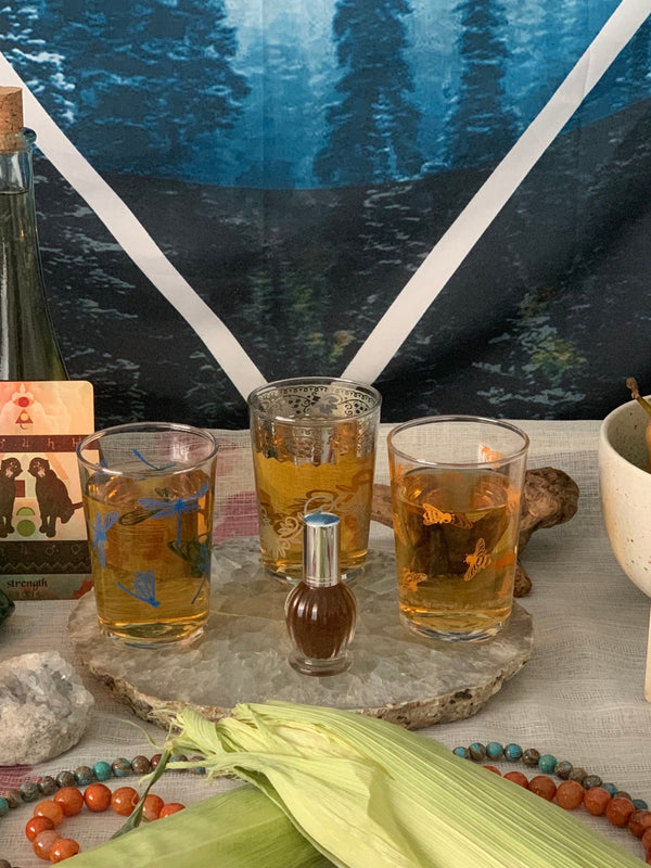 This is a personalized ritual perfume on a crystal altar with three glasses of honey wine around it.